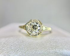 a close up view of a ring with a diamond in the center on a white surface