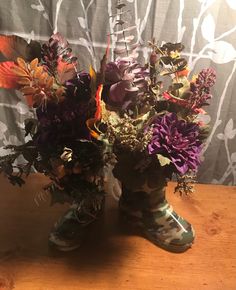 two boots with flowers in them sitting on a table