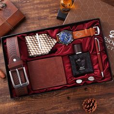 an assortment of men's accessories in a gift box on top of a wooden table