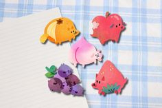 paper cutouts of different animals on a blue and white checkered table cloth next to a notepad