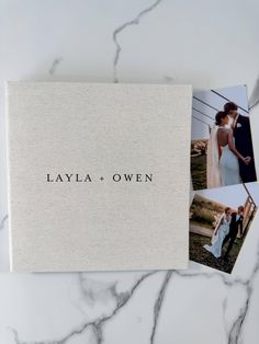 the wedding album is shown on top of a marble table with two photos in it