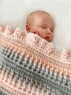 a newborn baby wrapped in a crochet blanket sleeping on top of a bed