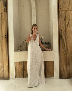 XS/S PRE-ORDER WILL SHIP AROUND 2/3 A summer favorite that’s sold out three times, the Gili Dress in beige check is the perfect balance between effortless style and all-day comfort. This breezy, lined maxi easily transforms from a laid-back beach cover-up to a chic evening look. With a dual neckline that lets you choose between a v-neck and high-neck, it offers styling possibilities for any occasion. Crafted from soft, breathable cotton, it’s your go-to for tropical vacations, summer nights out, Summer Dress Office Outfit, Coastal Boho Fashion, Coastal Chic Outfit, Coastal Auntie, Mum Uniform, Vietnam Clothes, Sac Diy, Get Ready For Summer, Stretchy Fabric