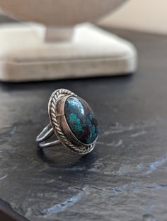 This is a gorgeous example of a handmade oval,  large turquoise Native American Ring. Size 3.5, it features stunning colors with dark turquoise against deep coppery accents. Measures: 7/8 " long Condition: this vintage ring shows signs of use and age. Please look at the pictures for details. It has surface scratches. The band itself is slightly uneven. Thank you for looking! Feel free to reach me with questions and visit my shop for additional art, books, holiday decor items, jewelry, or other unique gifts and home finds ♥ Vintage Chrysocolla Turquoise Ring, Southwestern Style Jewelry With Oval Natural Stones, Southwestern Oval Natural Stones Jewelry, Southwestern Style Oval Natural Stone Jewelry, Oval Chrysocolla Jewelry With Patina, Southwestern Turquoise Chrysocolla Ring, Southwestern Chrysocolla Turquoise Ring, Untreated Southwestern Oval Jewelry, Southwestern Turquoise Oval Cabochon Ring As Gift