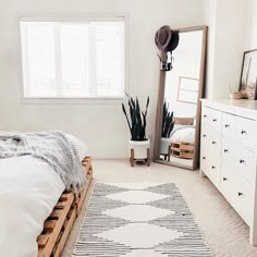 a bed room with a neatly made bed and a large mirror