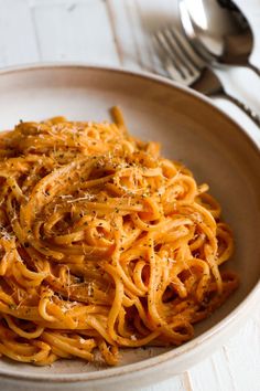 a white bowl filled with pasta on top of a table