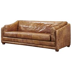 a brown leather couch sitting on top of a white floor