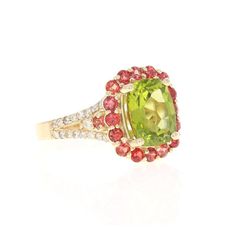 4.57 Carat Oval Cut Peridot Sapphire Diamond 14 Karat Yellow Gold Ring  This beautiful ring has an Cushion/Oval Cut Peridot that weighs 3.36 Carats. The ring is surrounded by 18 Red Sapphires that weigh 0.90 Carats and 34 Round Cut Diamonds that weighs 0.31 Carats. (Clarity: SI, Color: F) The total carat weight of this ring is 4.57 Carats. The Peridot measures at 9 mm x 11 mm and the face of the ring measures at 12 mm x 16 mm. Curated in 14 Karat Yellow Gold and weighs approximately 5.0 grams. T Oval Green Sapphire Ring With Halo Setting, Green Oval Sapphire Ring With Center Stone, Luxury Green Oval Cluster Ring, Gia Certified Green Oval Sapphire Ring, Luxury Multi-stone Peridot Ring, Luxury Peridot Multi-stone Rings, Green Multi-stone Oval Diamond Ring, Oval Green Multi-stone Diamond Ring, Oval Tsavorite Ring With Center Stone