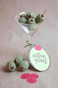 small crocheted balls in a martini glass with a tag saying olive you next to them