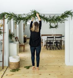 a woman standing in front of a table with christmas wreaths on top of it