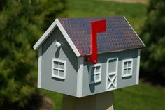 a house shaped mailbox with a red door