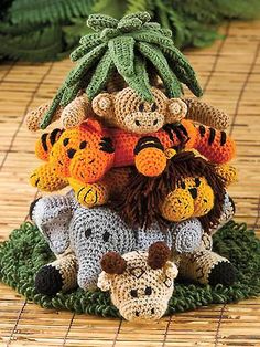 a group of stuffed animals sitting on top of each other in front of a plant