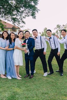 a group of people standing next to each other on top of a lush green field