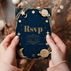 a person holding up a card with the word rsvp in gold on it