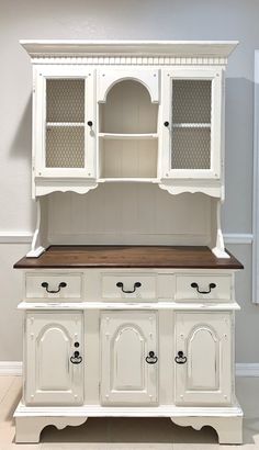 a white hutch with wooden top and drawers