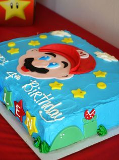 a birthday cake that is shaped like a mario bros character with stars on the side