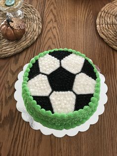 a green and white cake sitting on top of a wooden table next to a wicker basket