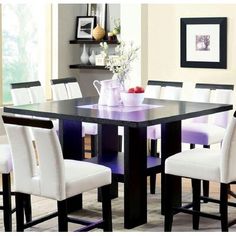 a dining room table with white chairs around it