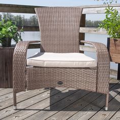 a chair sitting on top of a wooden deck next to a plant potted tree