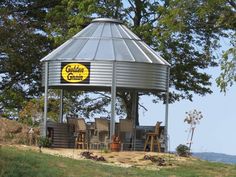 a large metal structure sitting on top of a lush green hillside