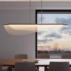 a dining room table and chairs in front of a large window with the sky outside