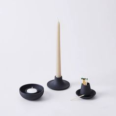 two candles and one candle holder on a white background