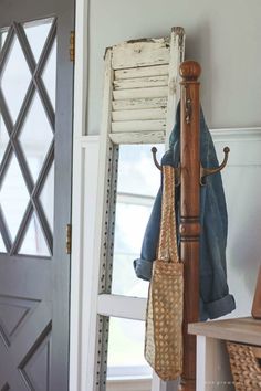 a coat rack with two umbrellas hanging from it's sides next to a door