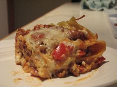 a white plate topped with lasagna casserole covered in cheese and meat