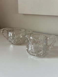 two glass dishes sitting on top of a white counter