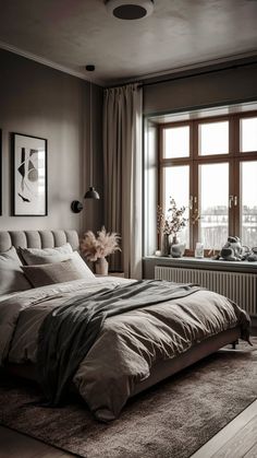 a bedroom with a large bed in front of a window and a rug on the floor