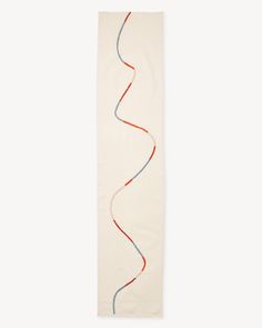 a white wall hanging with red, blue and grey lines on it's side