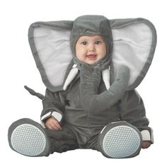 a baby sitting on the ground wearing an elephant costume