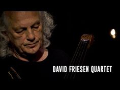 a man holding a violin in his right hand with the words david friesen quartet on it