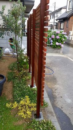 a wooden fence next to a flower garden