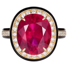 This ring is a bold statement of luxury and color, featuring a stunning 6.58-carat glass-filled ruby as its centerpiece. The ruby, measuring 12x10mm, boasts a rich, deep crimson color that commands attention. The process of glass filling enhances the appearance of the ruby, giving it a remarkable clarity and allowing it to capture light in a way that accentuates its vibrant hue. Surrounding the ruby is a halo of brilliant diamonds totaling 0.46 carats. These diamonds provide a sparkling contrast to the intensity of the ruby, illuminating the ring with their timeless elegance. The ring is crafted in 18 karat yellow gold, which complements the warmth of the ruby and adds a classic sophistication to the piece. The band features a sleek black enamel that frames the ruby and diamonds, creating Crimson Color, Gold For Sale, Enamel Ring, Ruby Diamond, Fine Jewelry Collection, Brilliant Diamond, Cluster Ring, Black Enamel, Statement Jewelry