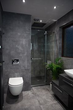 a bathroom with a toilet, sink and shower stall in the middle of it's walls