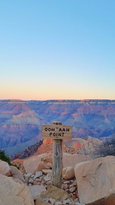 a wooden sign sitting on the side of a mountain