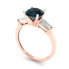 a rose gold engagement ring with two baguets on the side and an emerald green stone