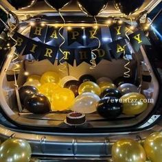 balloons and streamers are in the trunk of a car for a birthday party at night