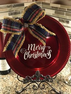 a red plate with a bow on it sitting on a counter next to some wine bottles