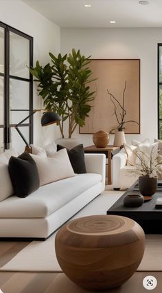 a living room filled with white furniture and lots of plants in the window sill