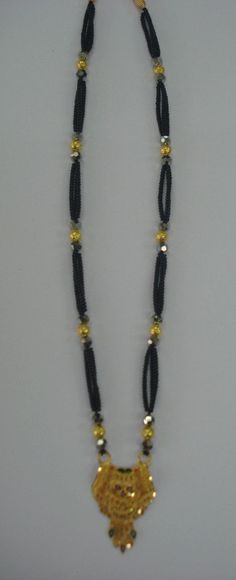 "20kt ETHNIC TRIBAL GOLD PENDANT BEADS NECKLACE FROM RAJASTHAN INDIA. GREAT HANDMADE DESIGN GOLD PENDANT STRING WITH 10pc GOLD BEADS & BLACK GLASS BEADS IN TRADITIONAL STYLE. necklace length can be adjust by back thread knot. Gross weight - 18.5 grams Pendant Height max. - 4.2 cm (1.6\") Pendant Width max.- 2.5 cm (1\") Material - 20kt yellow gold." Traditional Gold Beads With Black Details, Elegant Gold Beads For Diwali, Gold Necklace With Black Beads For Puja, Gold Jewelry With Black Beads For Puja, Gold Beads For Diwali Gifts, Festive Gold Beaded Necklaces With Black Beads, Gold Beaded Long Temple Necklace, Diwali Temple Jewelry Gold Beads, Elegant Yellow Necklace For Puja