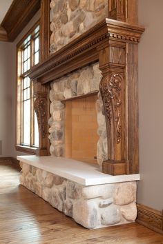 a stone fireplace in a large room with wood floors