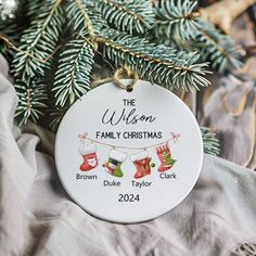 a personalized ornament hanging from a christmas tree with stockings and stockings on it