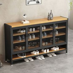 a black cabinet with wooden shelves filled with shoes