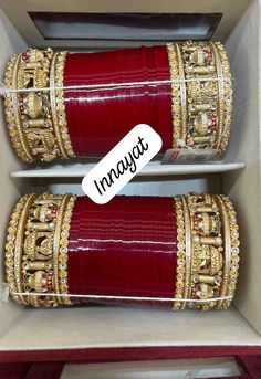 two red and gold bracelets in a box with the words imagit on it