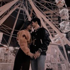 two people standing next to each other near a ferris wheel