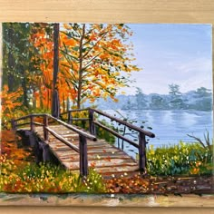 a painting of a wooden bridge over a lake in the fall with leaves on the ground