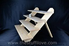 a wooden shelf sitting on top of a black background next to a cup and saucer