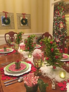 a dining room table decorated for christmas with plates and candy canes